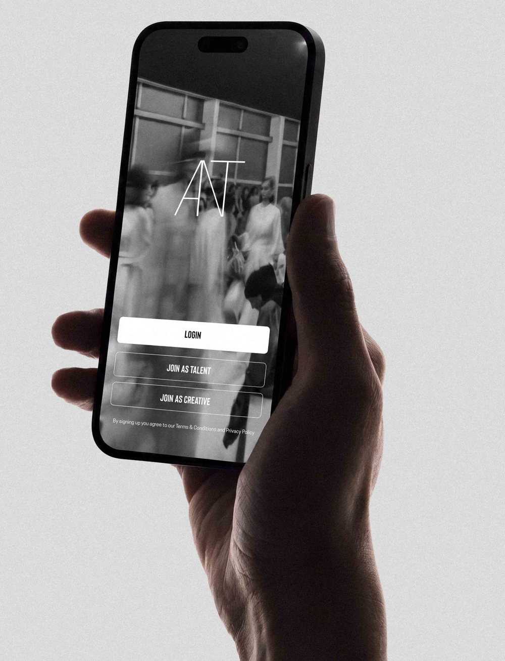 A hand holding a phone with the ANT Talent app open on the sign-in screen